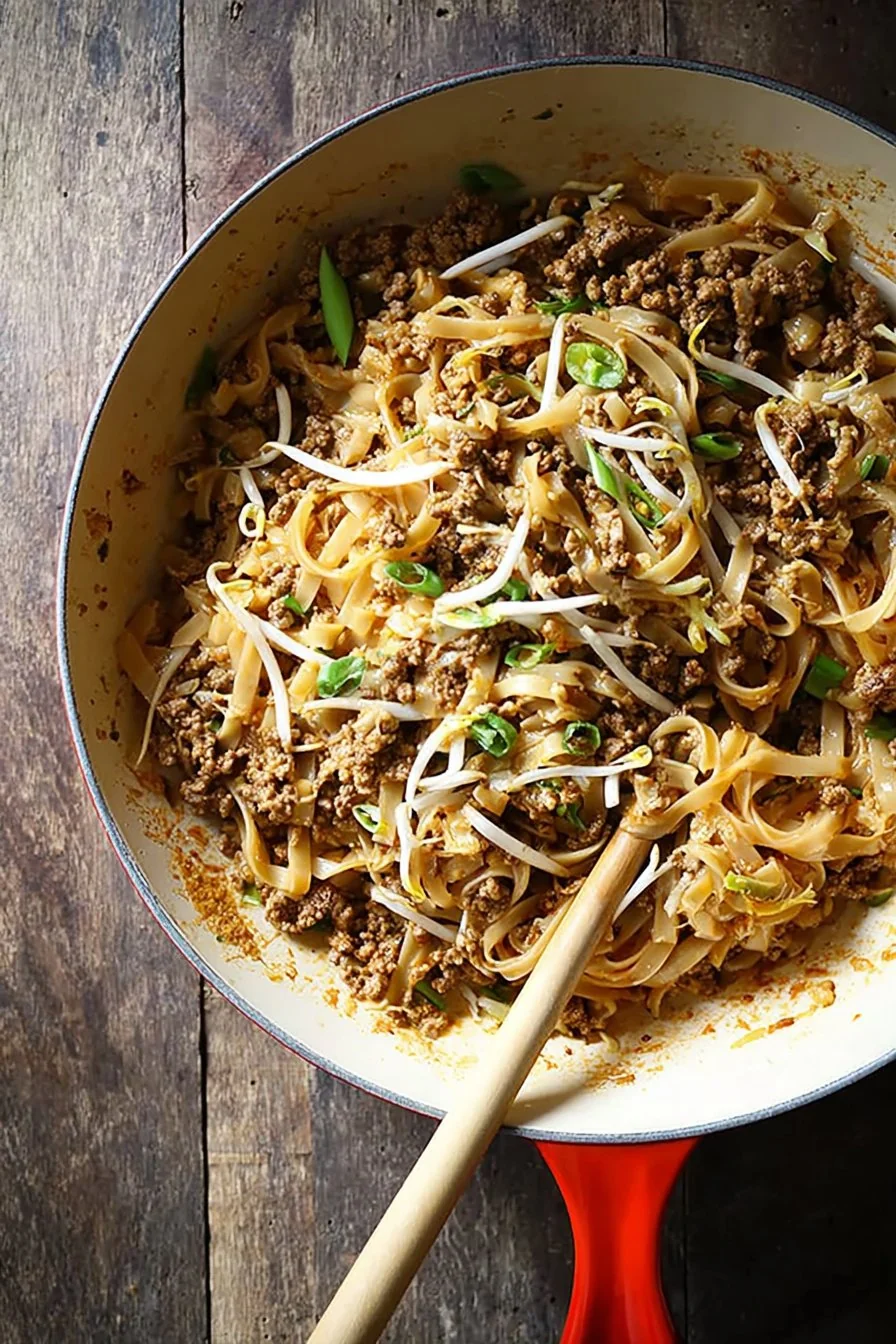 Ground Beef Pad Thai plated in a bowl, topped with crushed peanuts and fresh lime